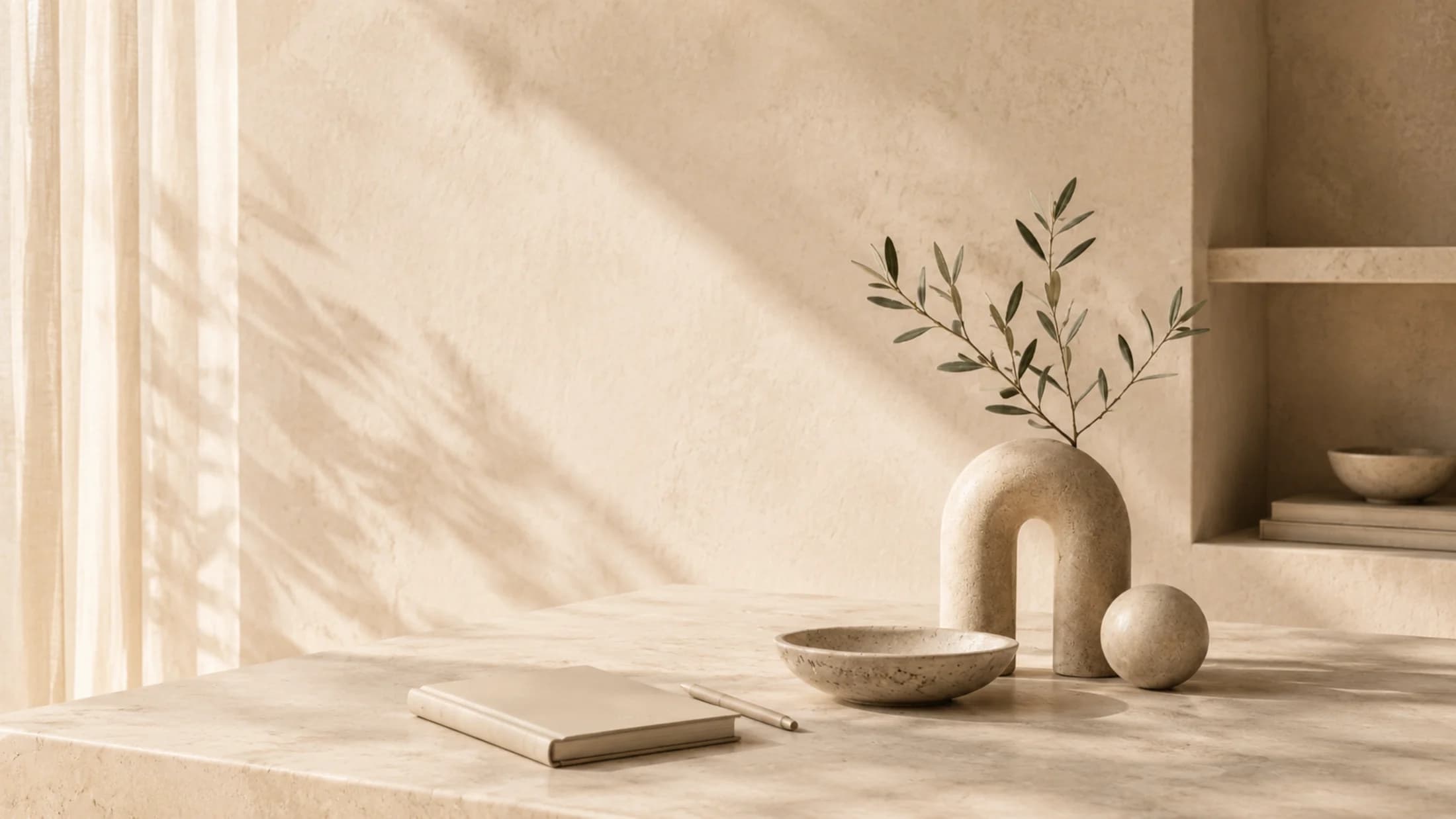 A warm tabletop scene with a notebook and ceramic vase.
